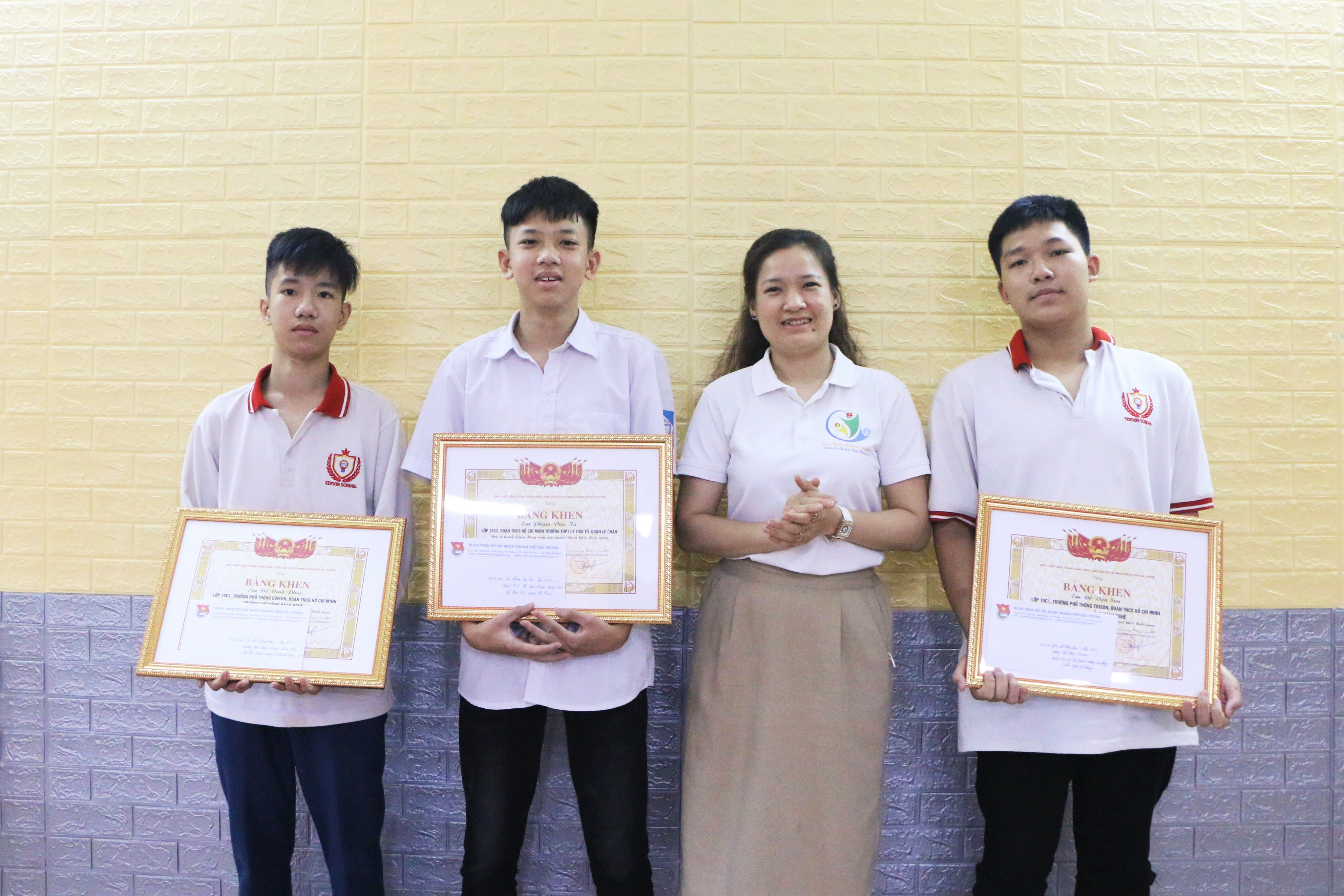 Pham Van Tu (L, 2nd), Do Dinh Phuc (L), and Do Van Son (R) receive certificates of honor after saving a senior woman from drowning in Hai Phong City, Vietnam, in this photo taken on June 6, 2022. Photo: Minh Huong / Tuoi Tre