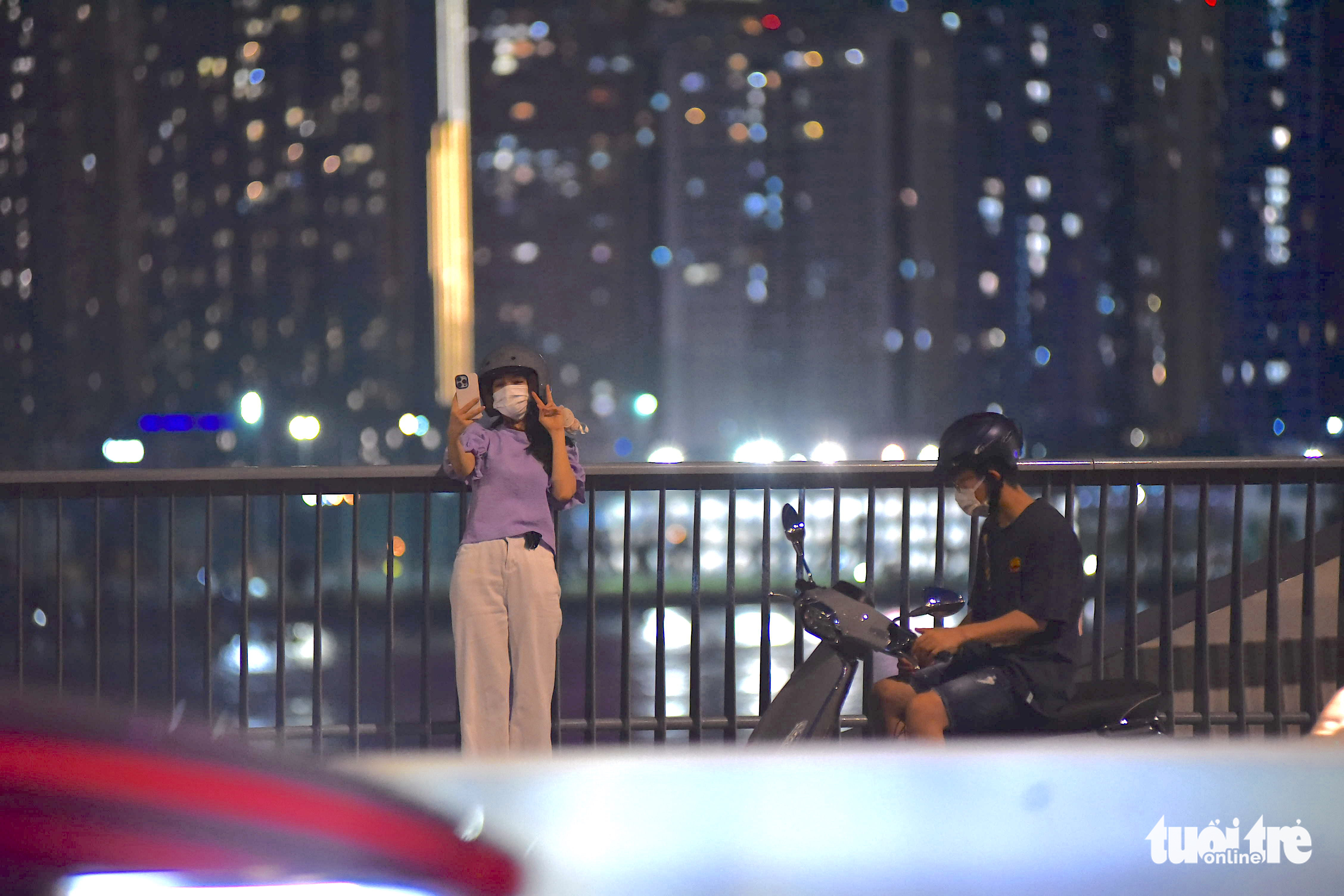 A man illegally parks his motorbike while his friend takes a selfie on the Thu Thiem 2 Bridge in District 1, Ho Chi Minh City. Photo: Ngoc Phuong / Tuoi Tre