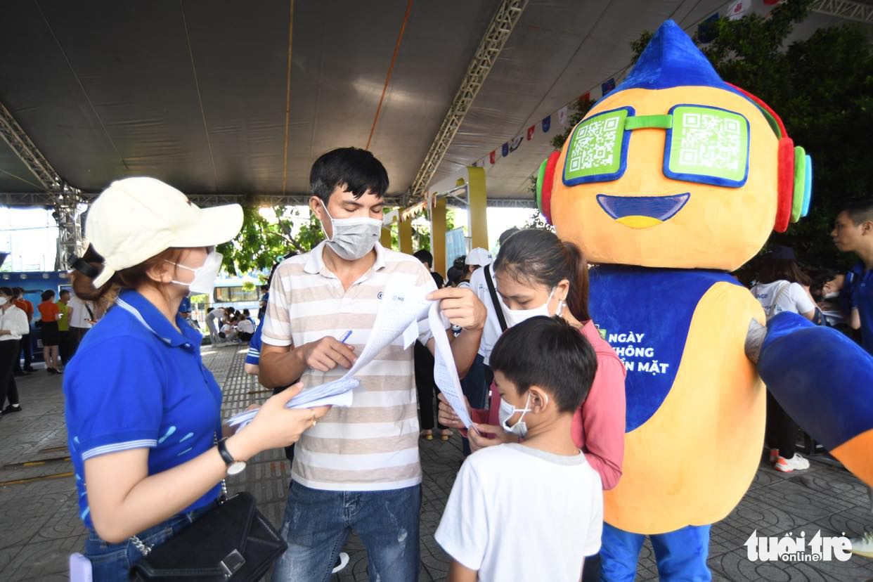 Visitors are instructed on how to use a cashless payment service at the Cashless Fair in Thu Duc City, Ho Chi Minh City, June 12, 2022. Photo: Minh Duy / Tuoi Tre