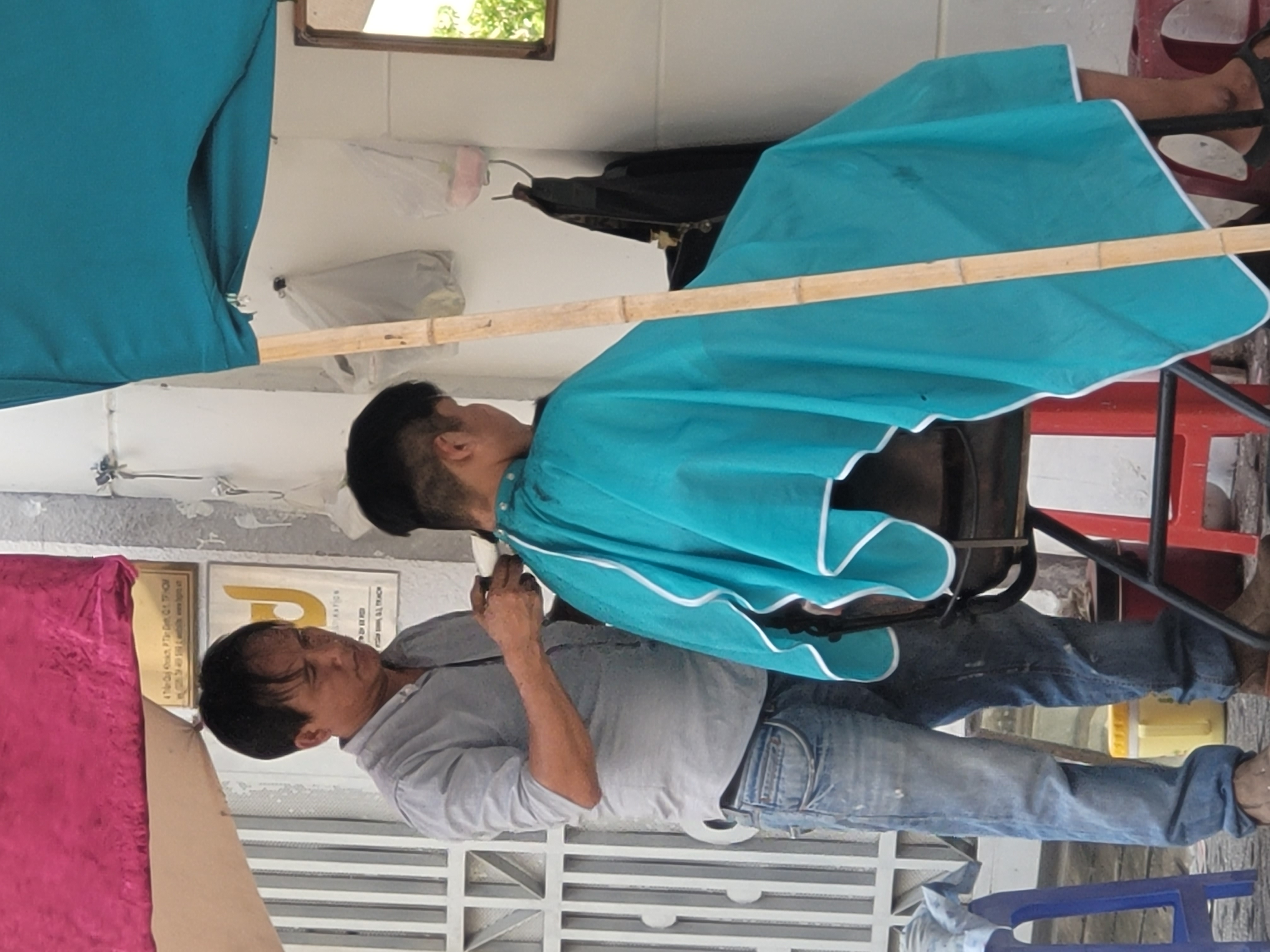 A man is having a haircut at a barber shop on the street in Ho Chi Minh City. Photo: Ray Kuschert / Tuoi Tre News