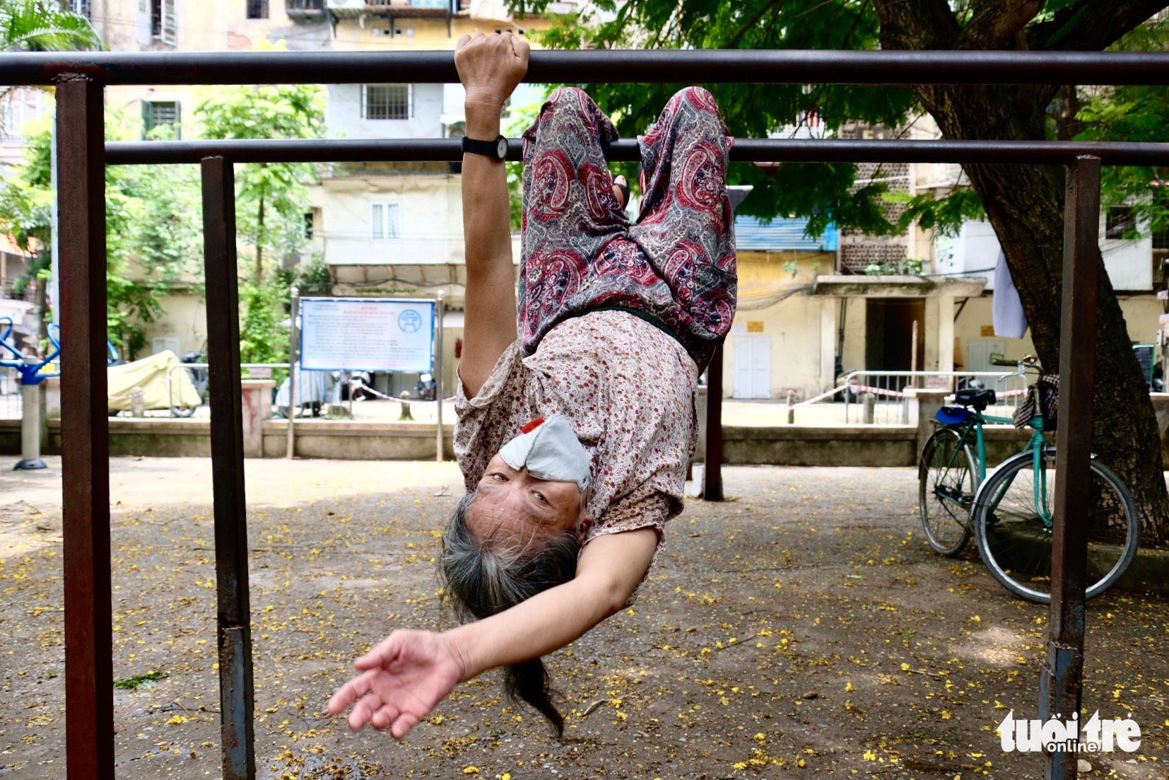 Le Thi Phong performs upside-down crunches on a bar at the E Yard on Van Chuong Street in Dong Da District, Hanoi. Photo: Nguyen Bao / Tuoi Tre