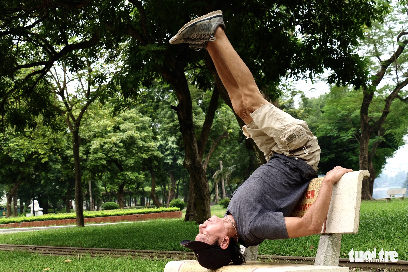 Nguyen Van Tram performs crunches on a stone bench at Thong Nhat Park in Dong Da District, Hanoi. Photo: Nguyen Bao / Tuoi Tre