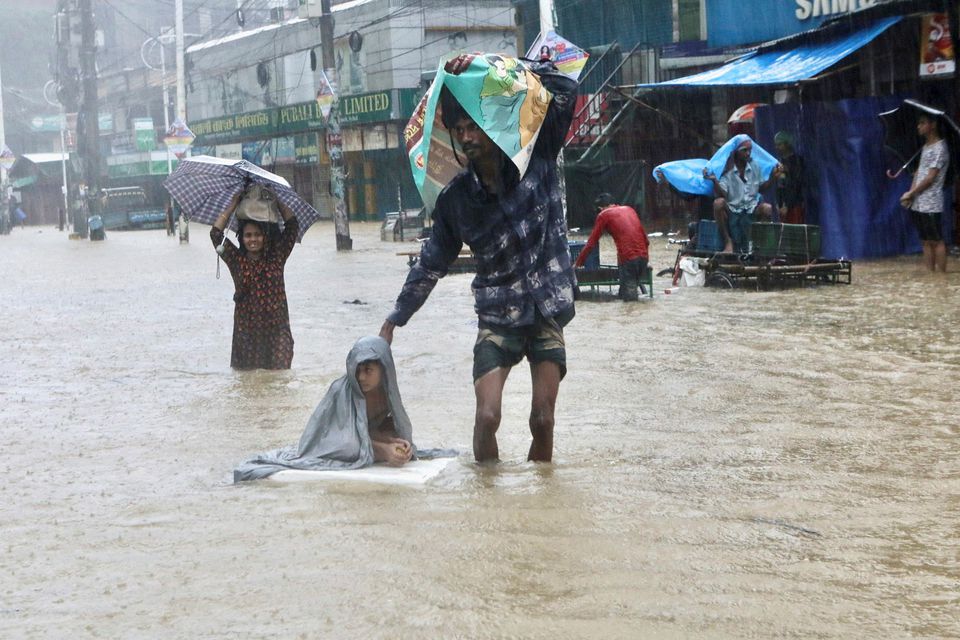 People wade through the water as they look for shelter during a flood, amidst heavy rains that caused widespread flooding in the northeastern part of the country, in Sylhet, Bangladesh, June 18, 2022. Photo: Reuters