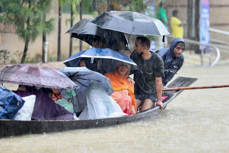 People get on a boat as they look for shelter during a flood, amidst heavy rains that caused widespread flooding in the northeastern part of the country, in Sylhet, Bangladesh, June 18, 2022. Photo: Reuters