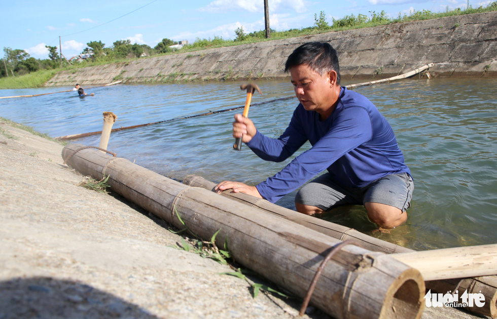 PE teacher Nguyen Viet Tuoc is seen repairing a part of his swimming pool on a canal in Hai Lang District, Quang Tri Province, central Vietnam in this image.