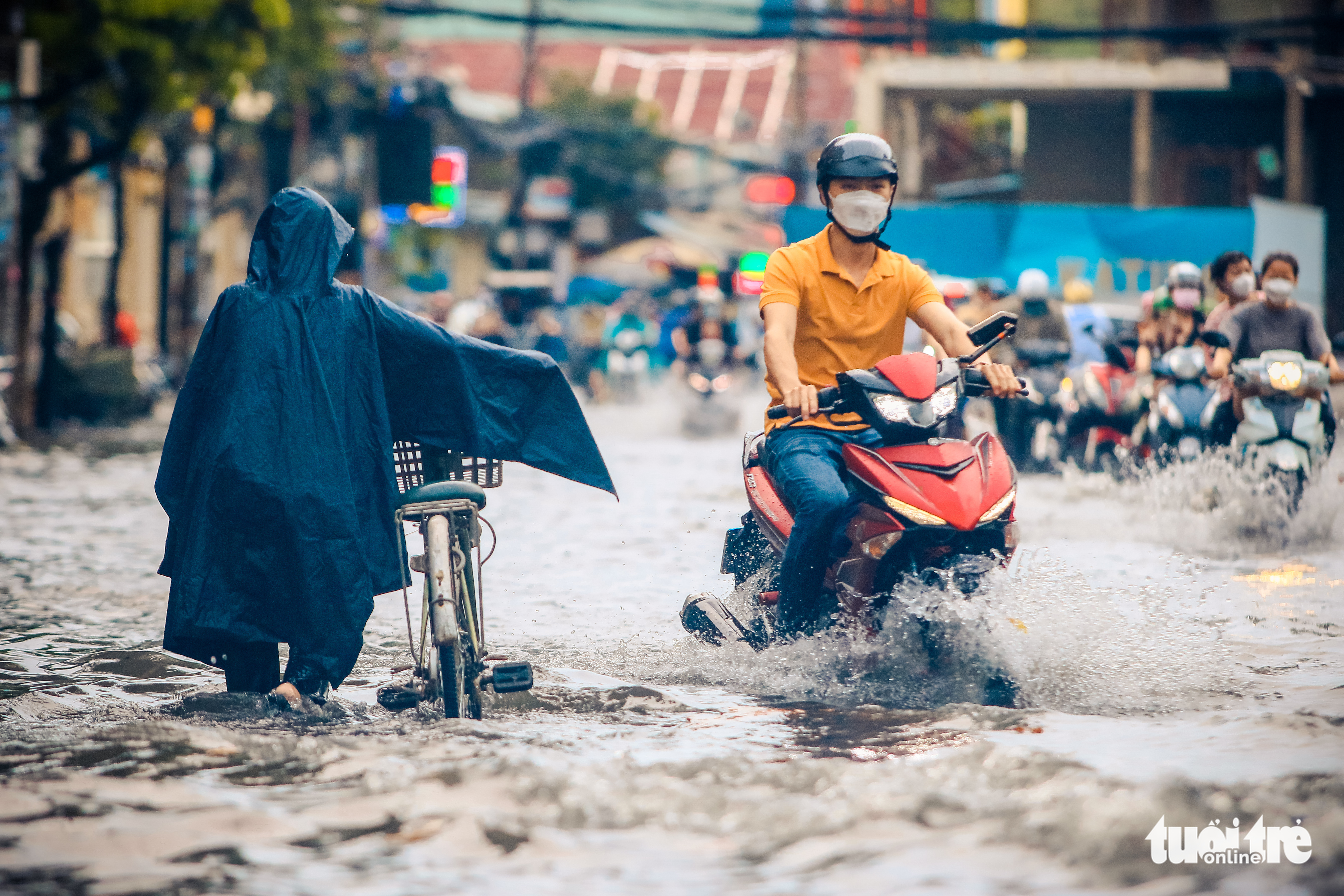 People travel on an inundated street in Ho Chi Minh City, July 20, 2022. Photo: Chau Tuan / Tuoi Tre