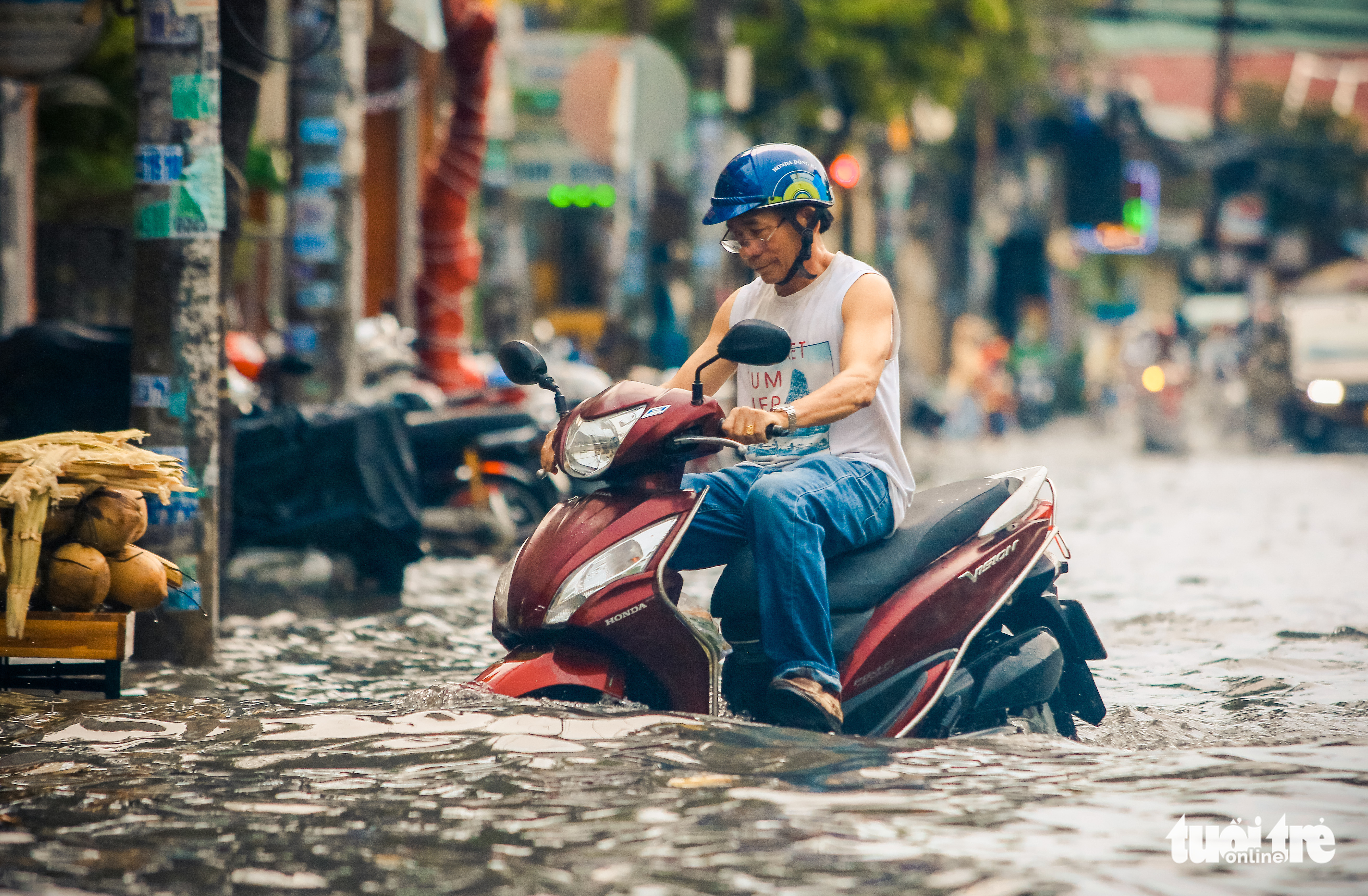 A man travels on knee-deep water in Ho Chi Minh City, July 20, 2022. Photo: Chau Tuan / Tuoi Tre
