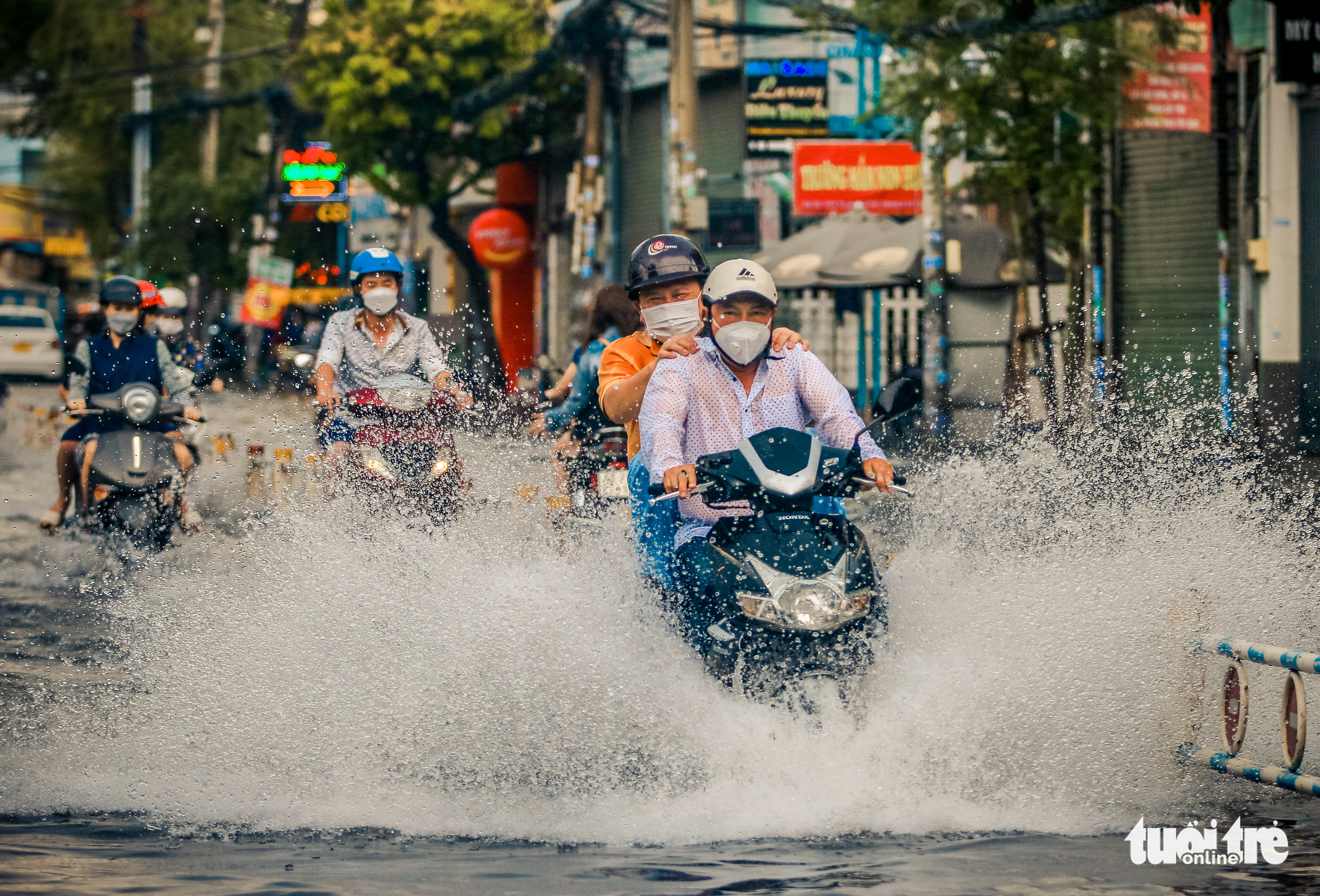 People travel on an inundated street in Ho Chi Minh City, July 20, 2022. Photo: Chau Tuan / Tuoi Tre