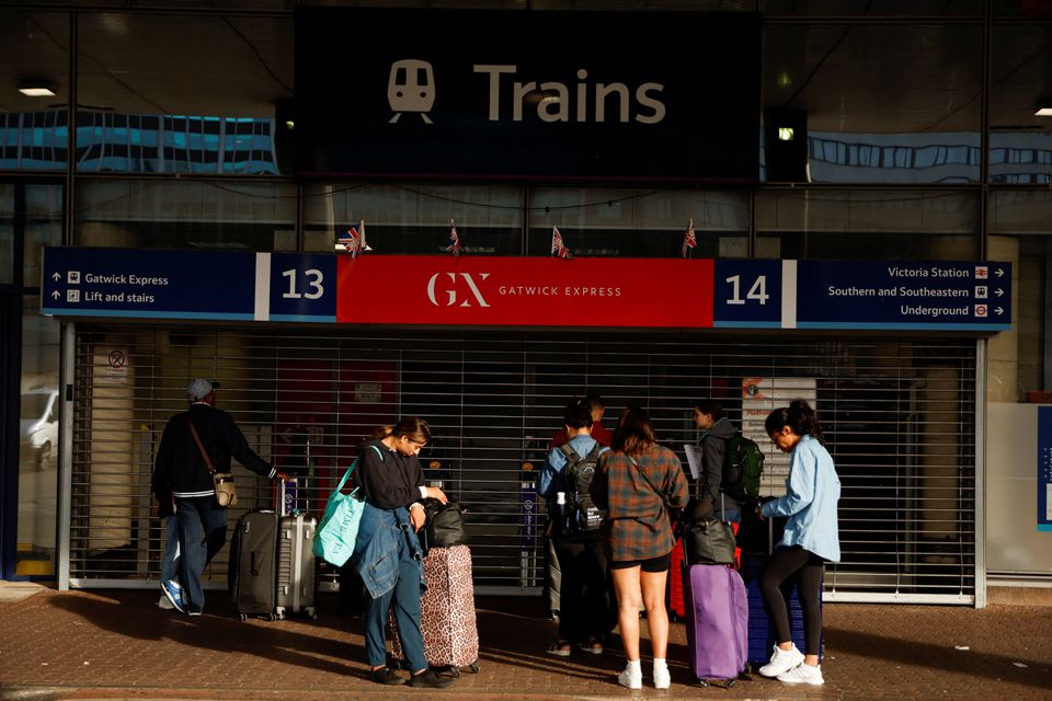 Travellers stand outside the closed entrance to the Gatwick Express train service at Victoria Station in London, Britain June 21, 2022. Photo: Reuters