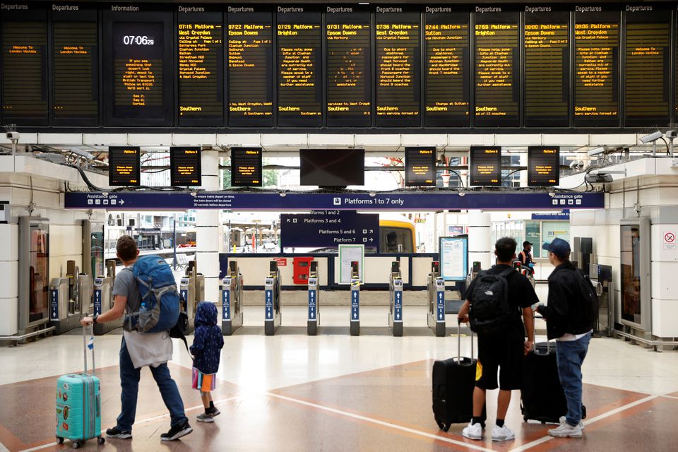 People look at the departures board at Victoria Station, in London, Britain June 21, 2022. Photo: Reuters