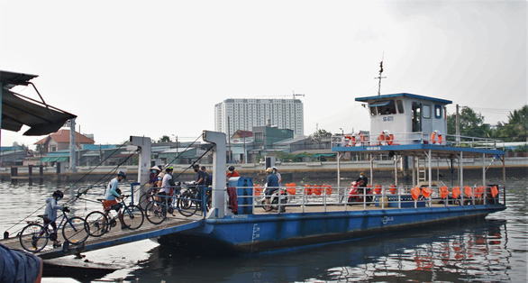 Cyclists take the ferry on the Saigon River in early morning. Photo: Huynh Vy / Tuoi Tre