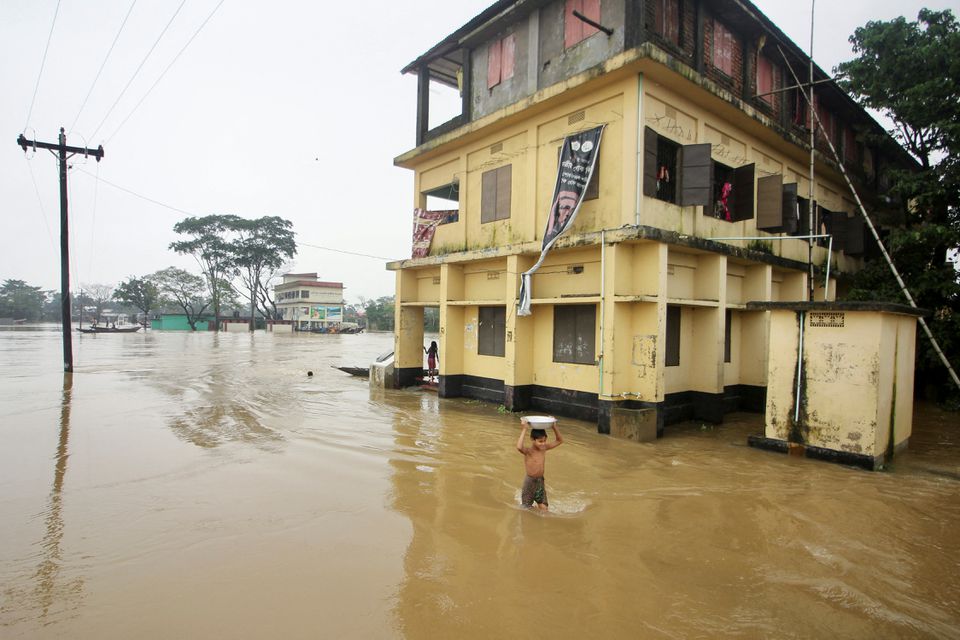A boy wades through a flooded area during a widespread flood in the northeastern part of the country, in Sylhet, Bangladesh, June 19, 2022. Photo: Reuters