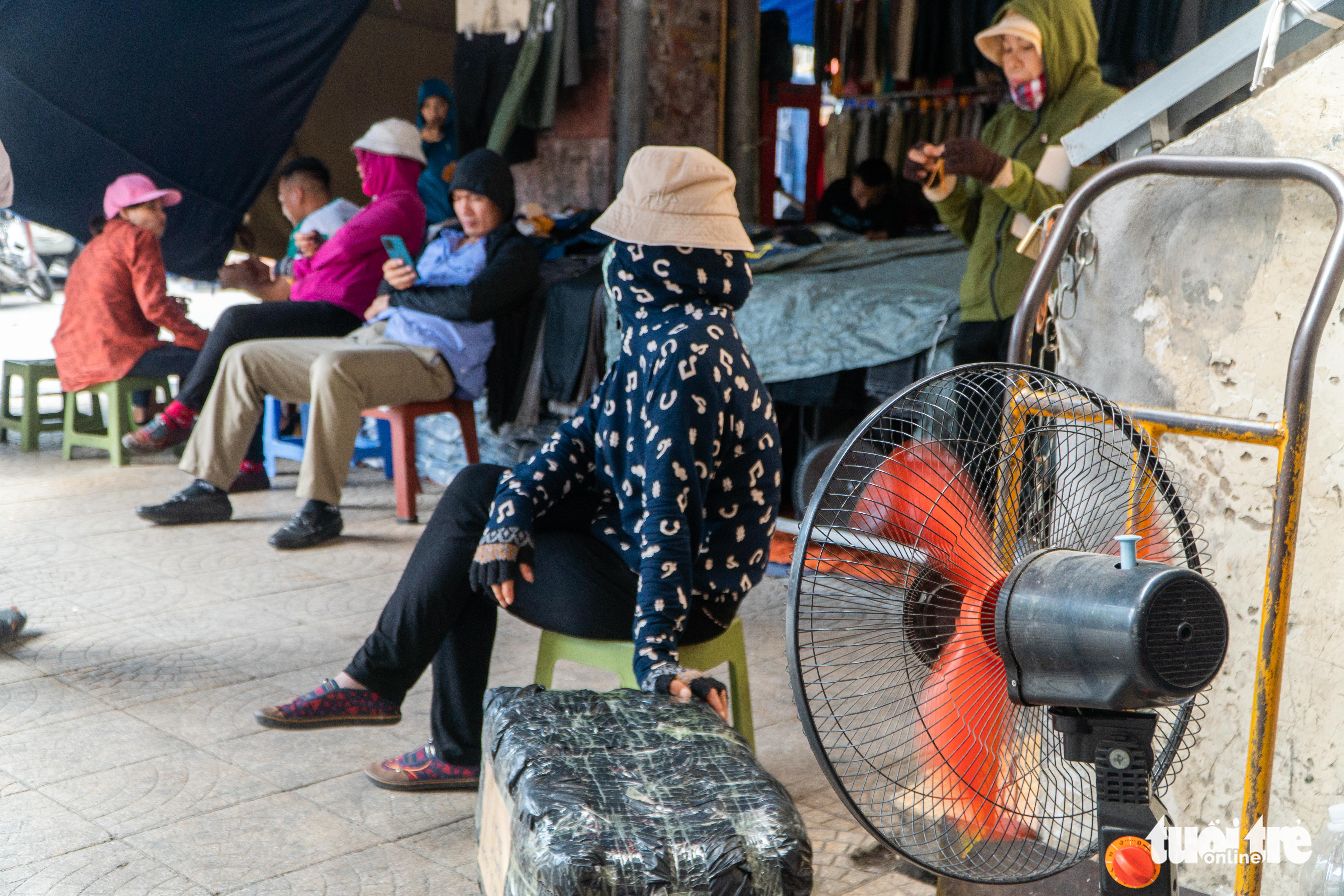 A woman sits in front of an electric fan to cope with the heat in Hanoi, June 21, 2022. Photo: Pham Tuan / Tuoi Tre
