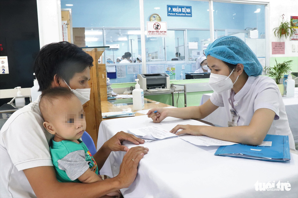A nurse gives advice to a parent on how to take care of his child, who suffers a respiratory disease, at the respiratory department of Children’s Hospital 1 in District 10, Ho Chi Minh City, June 2022. Photo: Xuan Mai / Tuoi Tre