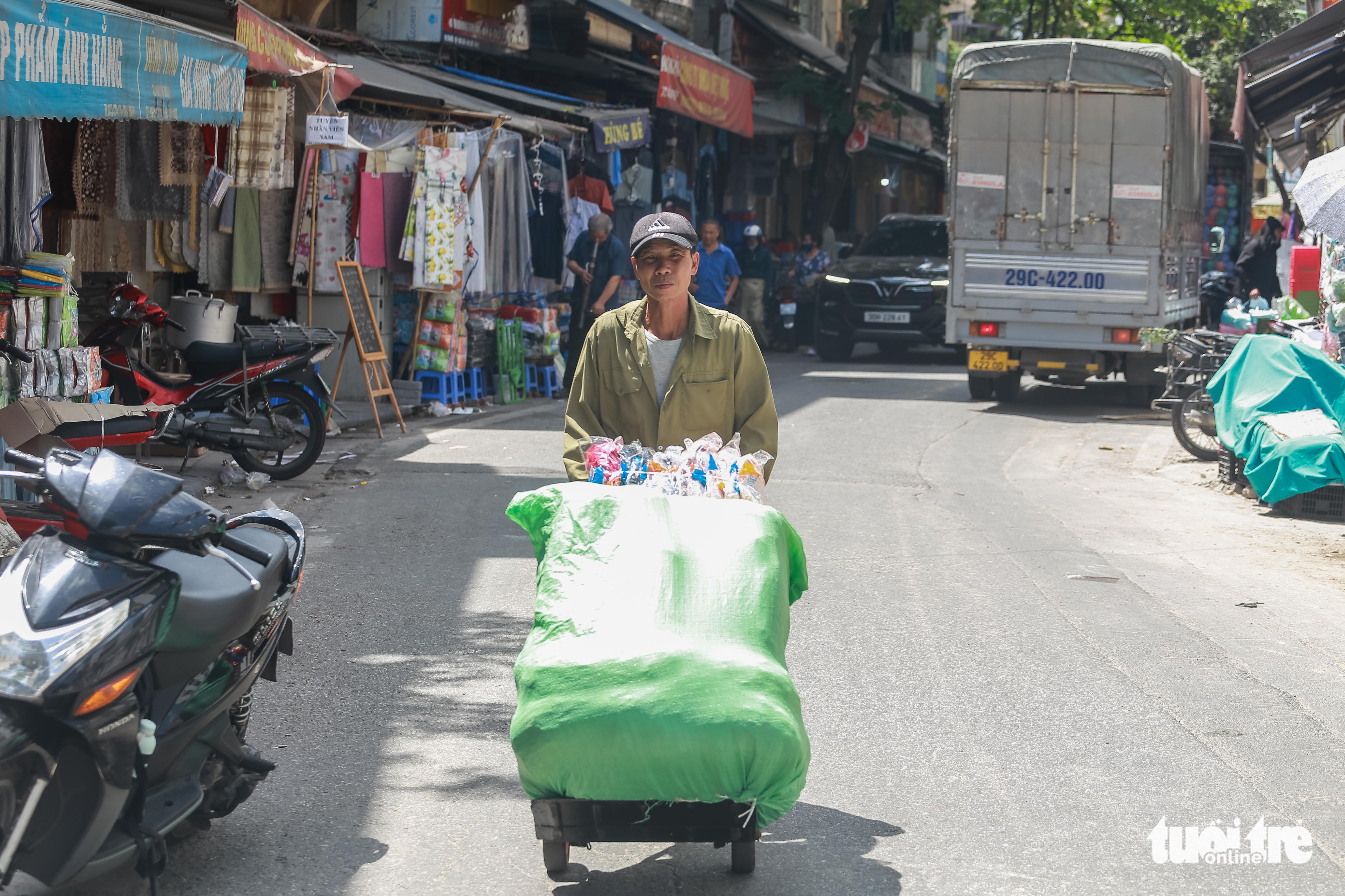 A porter works in the hot weather at a market in Hanoi, June 21, 2022. Photo: Pham Tuan / Tuoi Tre