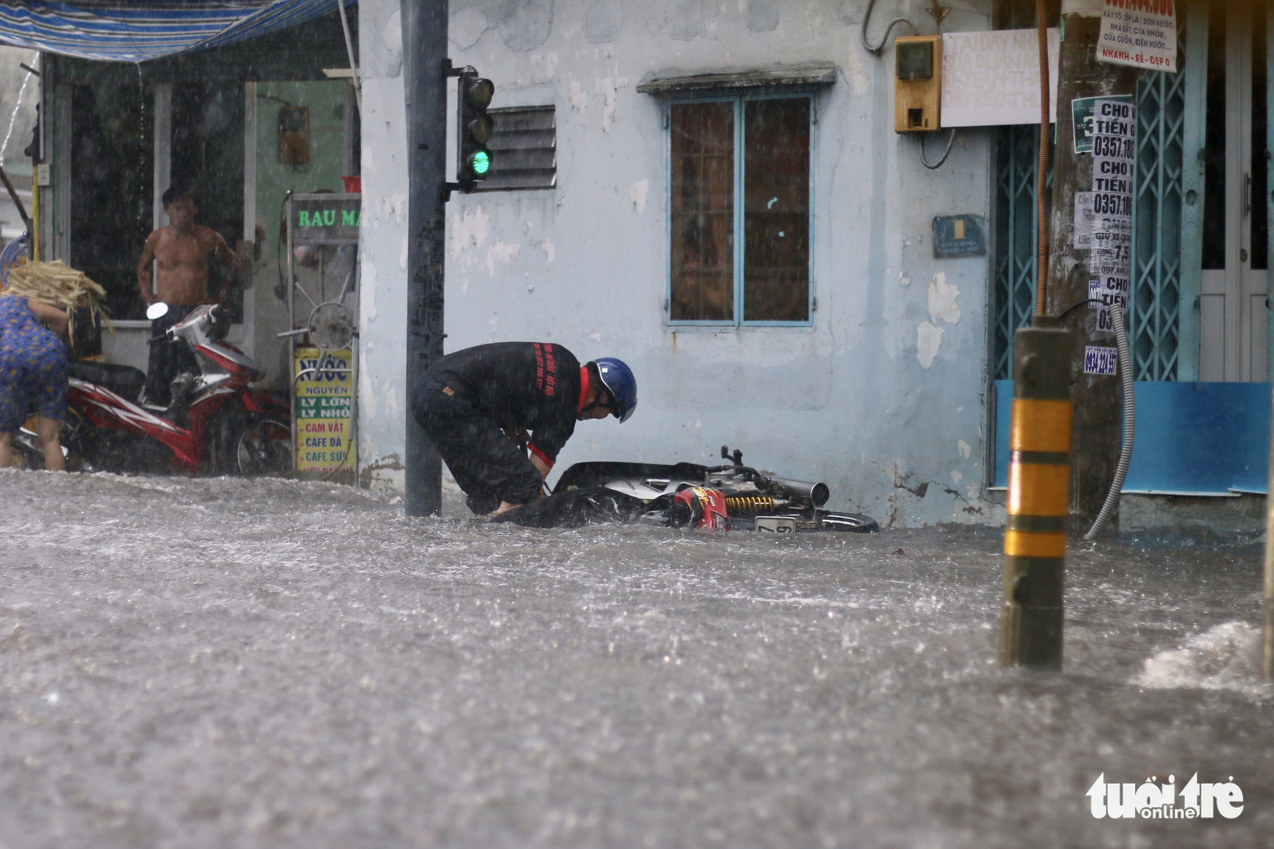 A man falls off his motorbike on an inundated street in Ho Chi Minh City, June 22, 2022. Photo: Tuoi Tre