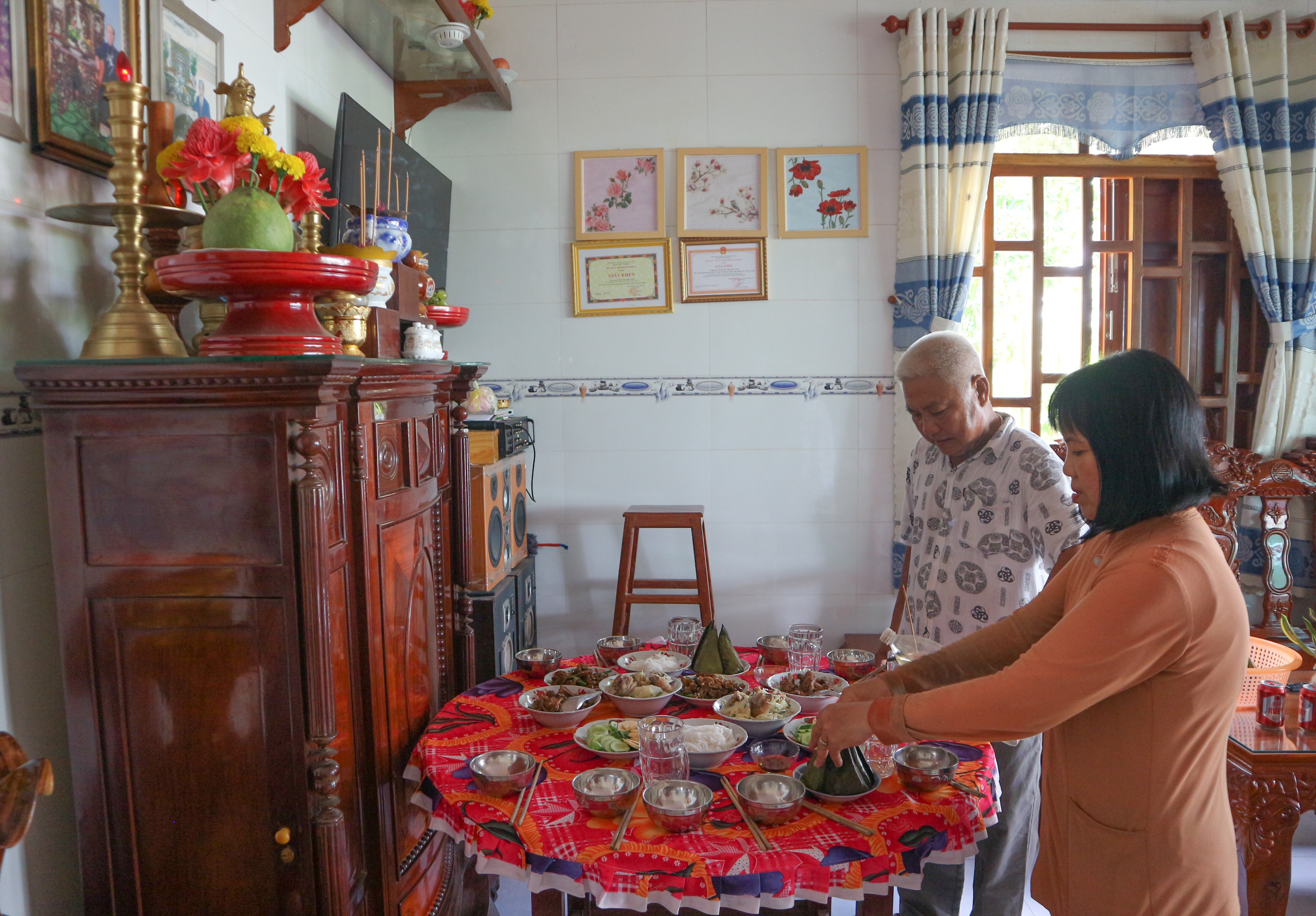 Nguyen Thi Kim Lan and her husband, Nguyen Van Phung, serve 'banh it' as an offering during their father’s death anniversary at their house at My Ngai Communes, Cao Lanh City, Dong Thap Province. Photo: Ngoc Phuong / Tuoi Tre News.