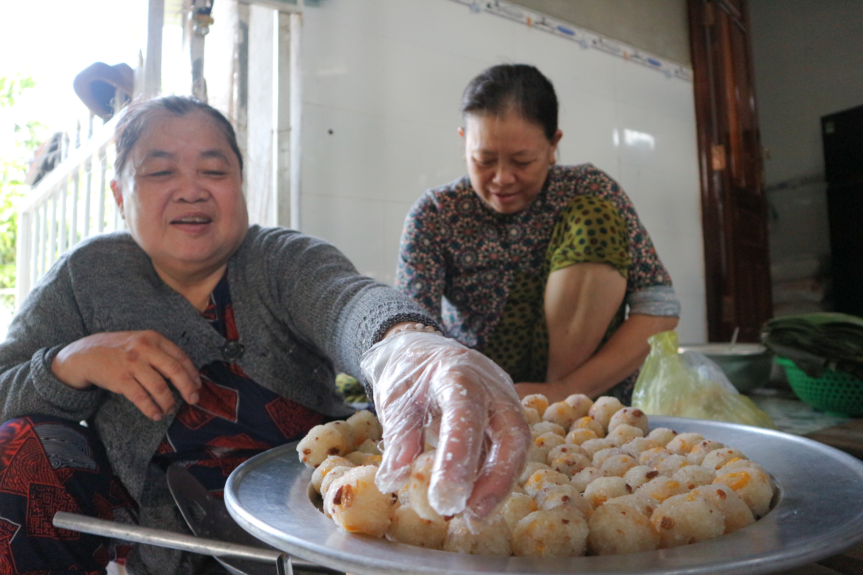 Kim Van (Lan’s sister) and Thuy (Lan’s niece) shapes coconut filling into small balls. Photo: Ngoc Phuong / Tuoi Tre News
