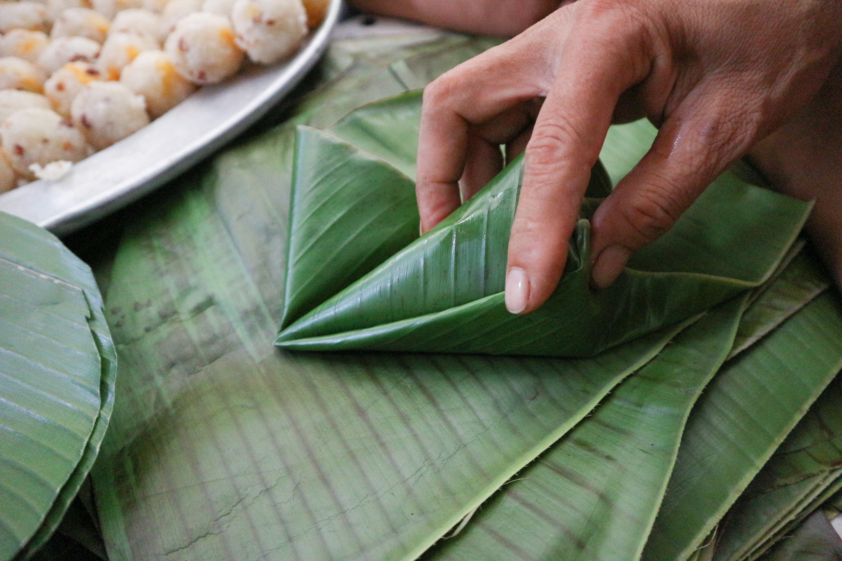 The ‘dough’ is wrapped in two layers of banana leaves and formed into a pyramid. Photo: Ngoc Phuong / Tuoi Tre News