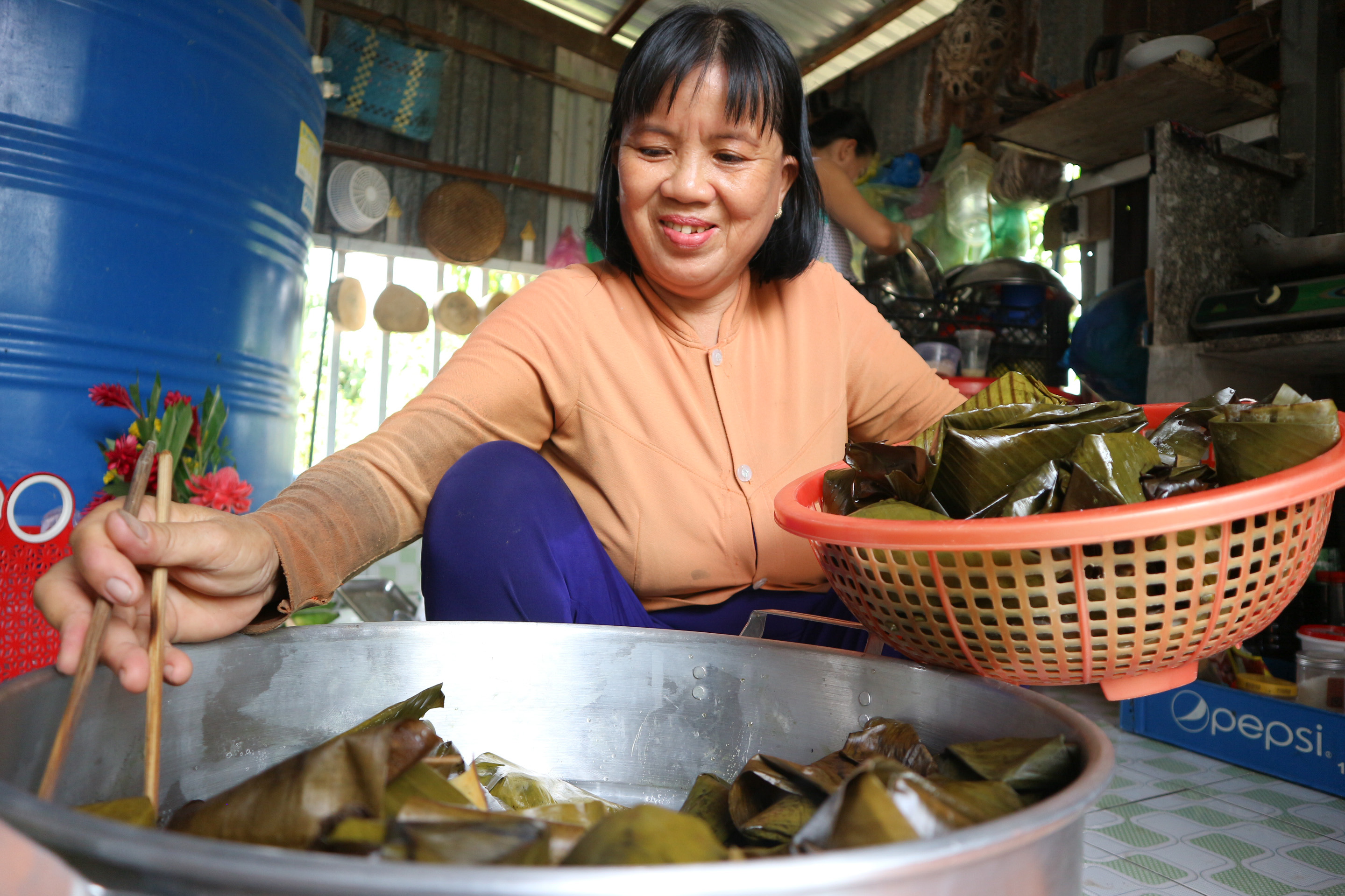 Nguyen Thi Kim Lan takes cooked 'banh it' out of the pot. Photo: Ngoc Phuong / Tuoi Tre News