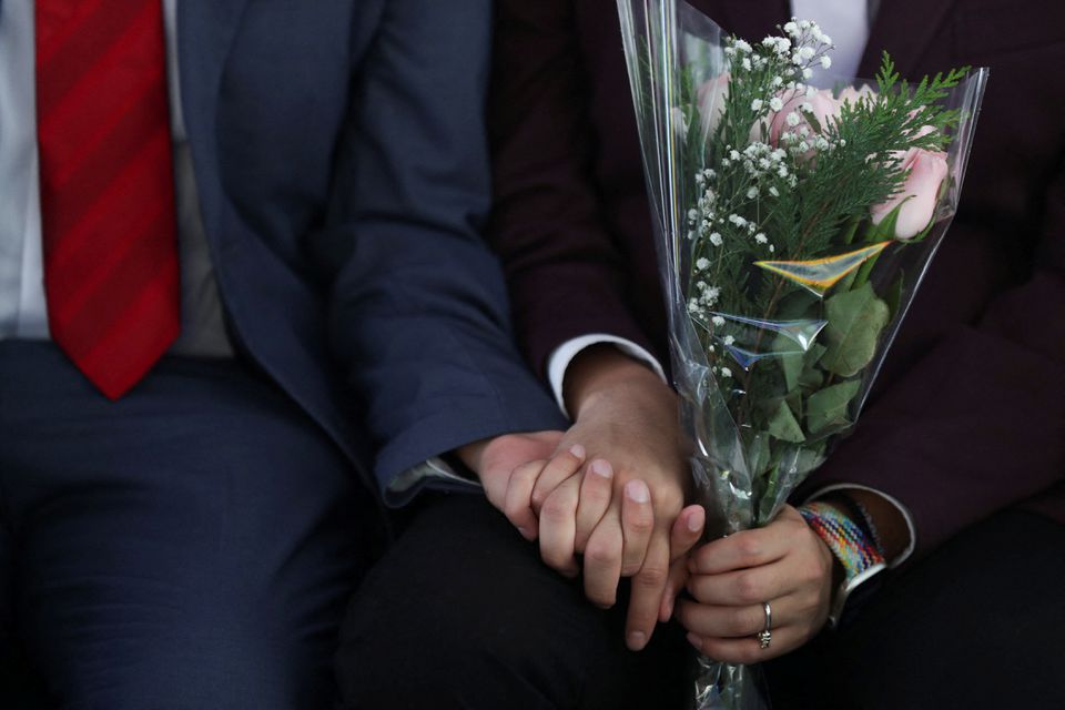 A couple holds hands as they celebrate LGBTQ+ pride month with a massive wedding of same sex couples in Mexico City, Mexico, June 24, 2022. Photo: Reuters
