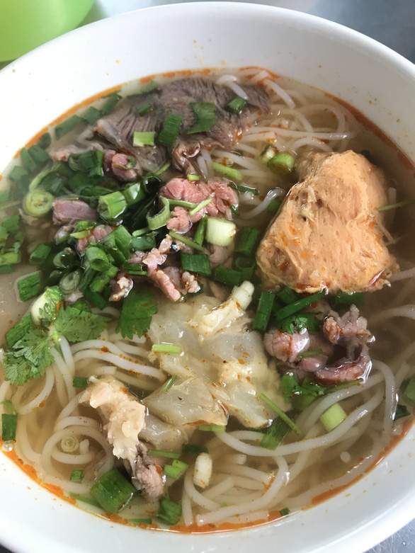 ‘Bun bo Hue’ (Hue spicy beef noodle soup) is popular in all regions in Vietnam but the noodle soup in Hue has its own taste. The stock is very complicated and cooked meticulously with many spices. The beef, pork and crab cake are fresh. The dish served with herbs will satisfy picky eaters. Photo: Ngoc Quyen / Tuoi Tre