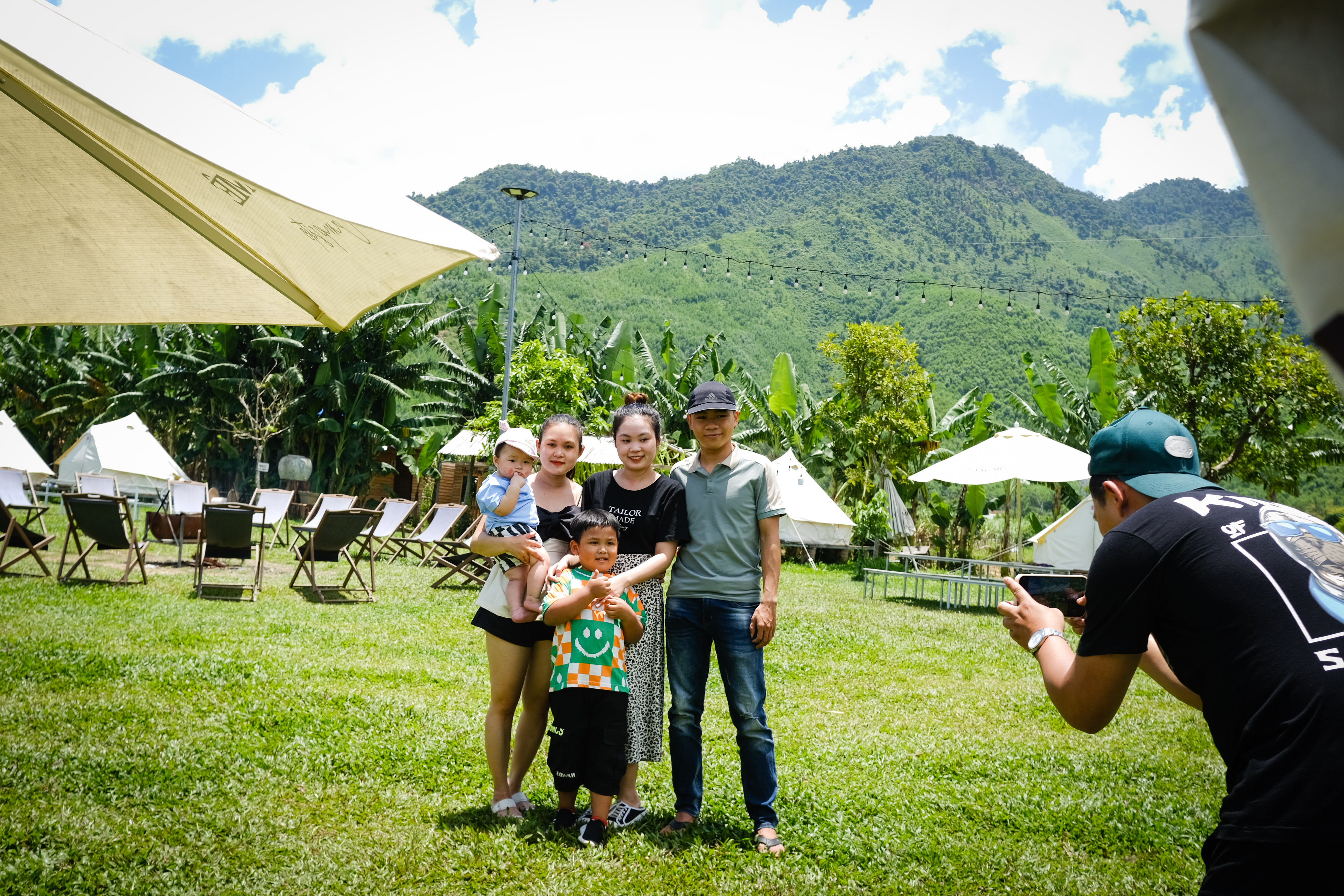 A family takes a photo at a camping site along the Cu De River in Hoa Bac Commune, Hoa Vang District, Da Nang City, Vietnam. Photo: T.L. / Tuoi Tre