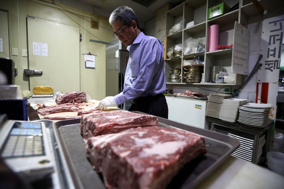 Lee Sang-jae, owner of a meat restaurant, cuts meat at a restaurant in Seoul, South Korea, June 23, 2022. Photo: Reuters