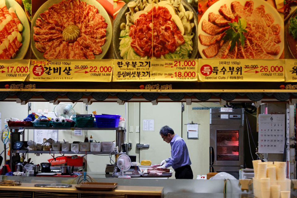 Lee Sang-jae, owner of a meat restaurant, cuts meat at a restaurant in Seoul, South Korea, June 23, 2022. Photo: Reuters