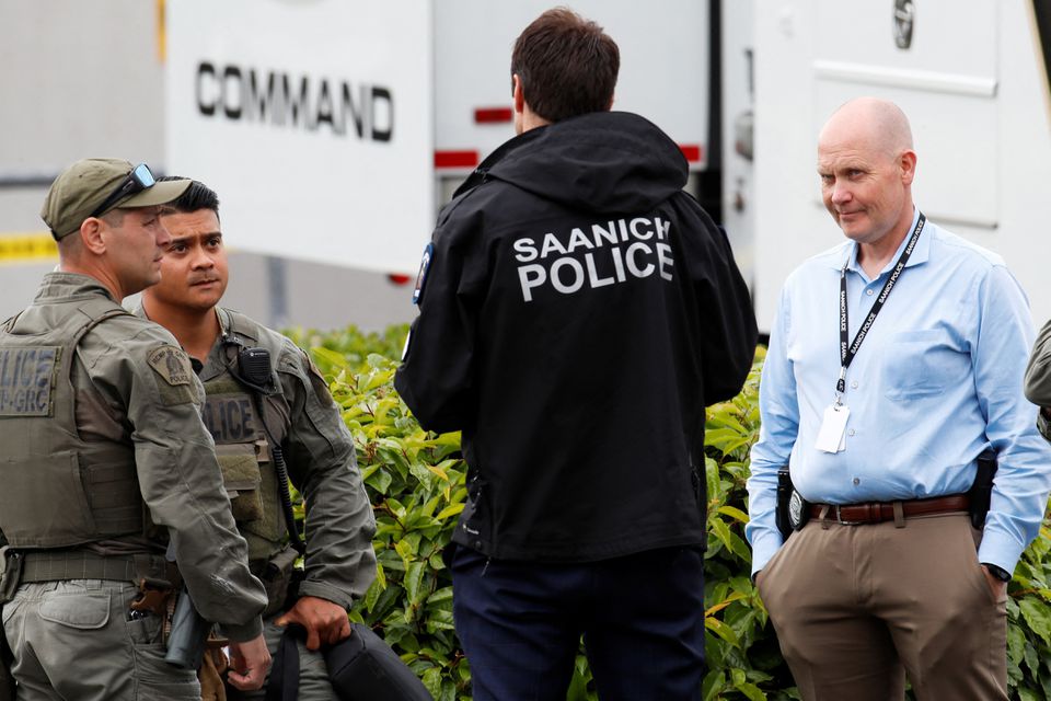 Police officers gather after two armed men entering a bank were killed in a shootout with the police in Saanich, British Columbia, Canada June 28, 2022. Photo: Reuters
