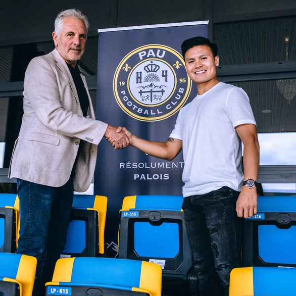 Nguyen Quang Hai (R) shakes hands with Pau FC president Bernard Laporte-Fray after officially joining the French club on June 29, 2022. Photo: Dac Van Team