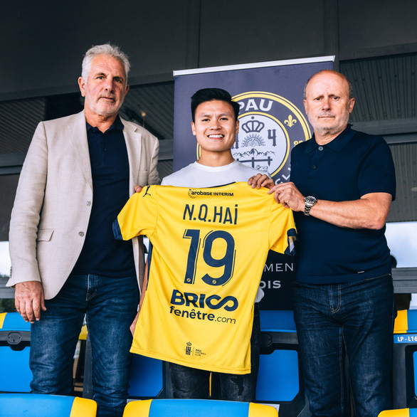 Nguyen Quang Hai (C) holds his No. 19 jersey in this picture with Pau FC president Bernard Laporte-Fray (L) and vice president Joel Lopez after joining the French club on June 29, 2022. Photo: Pau FC