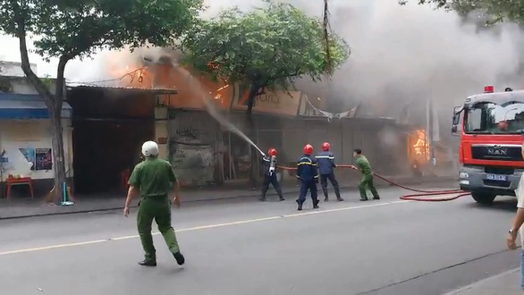 Firefighters spray water on a fire at a painting shop in District 1, Ho Chi Minh City, July 1, 2022. Photo: Minh Hoa / Tuoi Tre