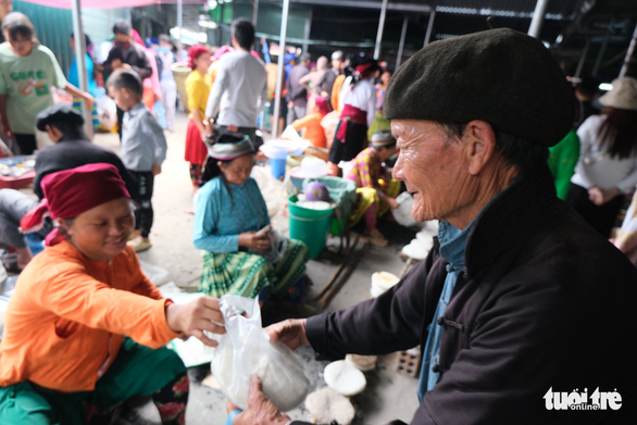 A local buys ‘banh ngo nep’ from a seller at a market fair in Dong Van Town, Ha Giang Province, Vietnam. Photo: Ha Thanh / Tuoi Tre