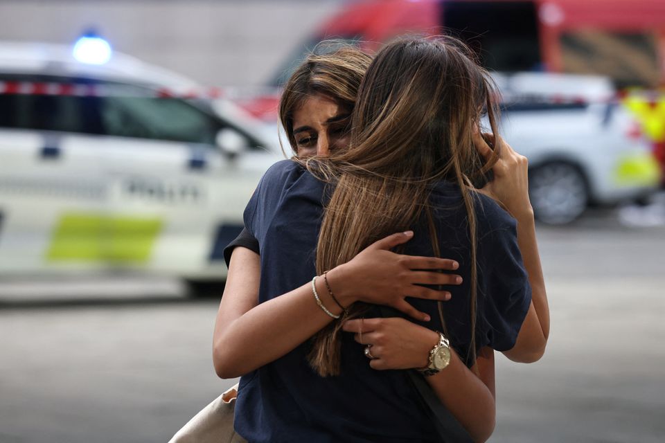 People embrace outside Fields shopping center, after Danish police said they received reports of a shooting at the site, in Copenhagen, Denmark, July 3, 2022. Ritzau Scanpix/Olafur Steinar Gestsson via Reuters