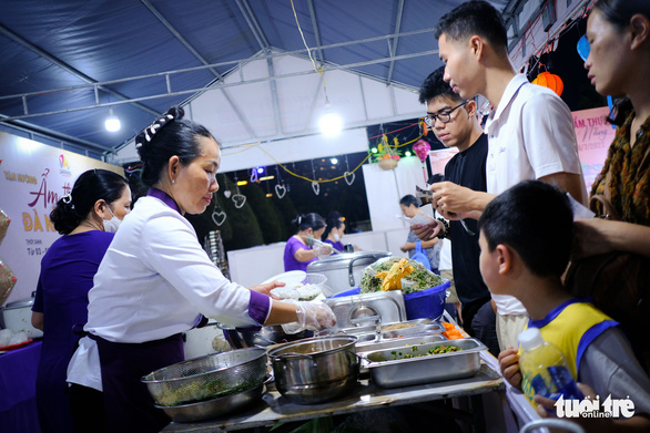 Tourists buy food from a stall at the Da Nang food festival at Bien Dong Park, Da Nang, Vietnam on July 3, 2022. Photo: Tan Luc / Tuoi Tre