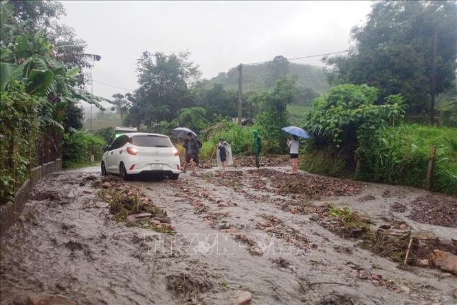 A car moves through debris after a downpour triggered a landslide on National Highway 12 in Dien Bien Province, Vietnam, July 3, 2022. Photo: Vietnam News Agency