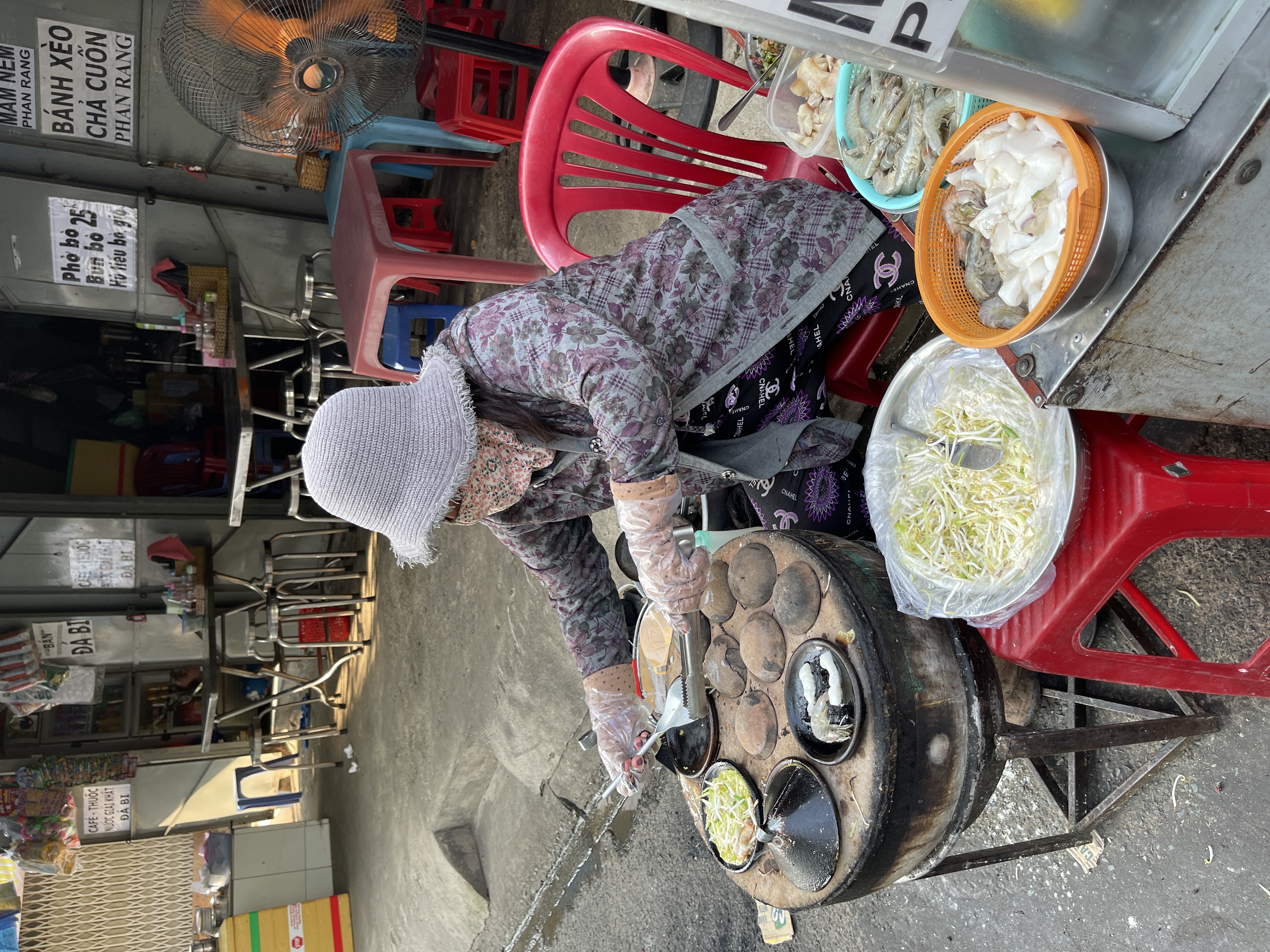 A woman sells Phan Rang-styled 'banh xeo' (Vietnamese savory sizzling crepes) and 'banh can' (savory mini pancakes)