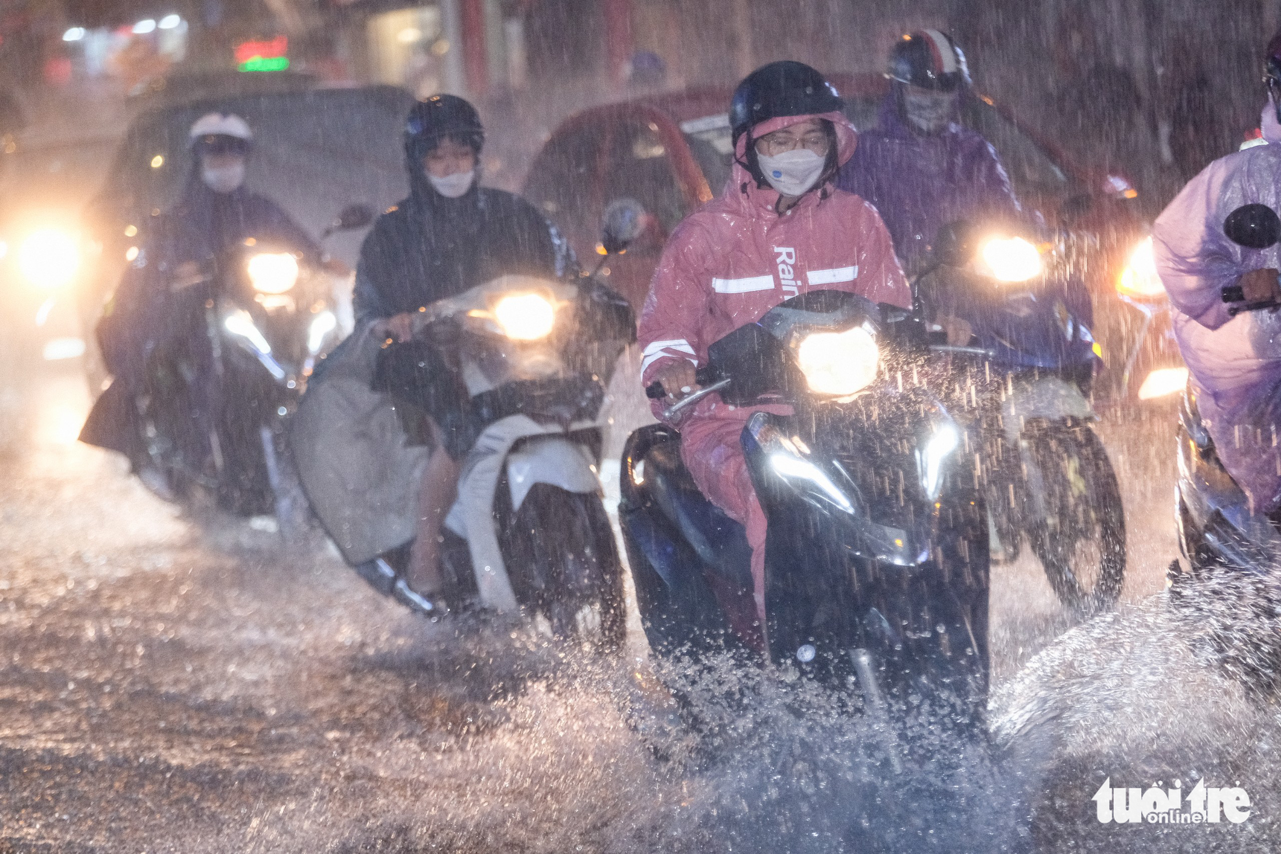 People travel in heavy rain on a street in Hanoi, July 5, 2022. Photo: Nam Tran / Tuoi Tre