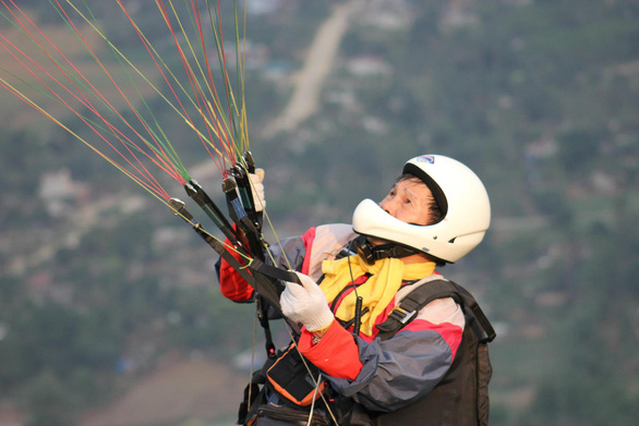 Nguyen Huu Nam has been involved in paragliding for over 15 years and has perfected his skills to a great extent. Here he is controlling the chute.