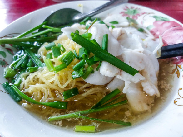 A bowl of ‘hu tieu mi ca’ (white rice noodles mixed with golden egg noodles and fish) topped with garlic chives at Phat Map stall on Calmette Street, District 1, Ho Chi Minh City, Vietnam. Photo: Minh Duc / Tuoi Tre