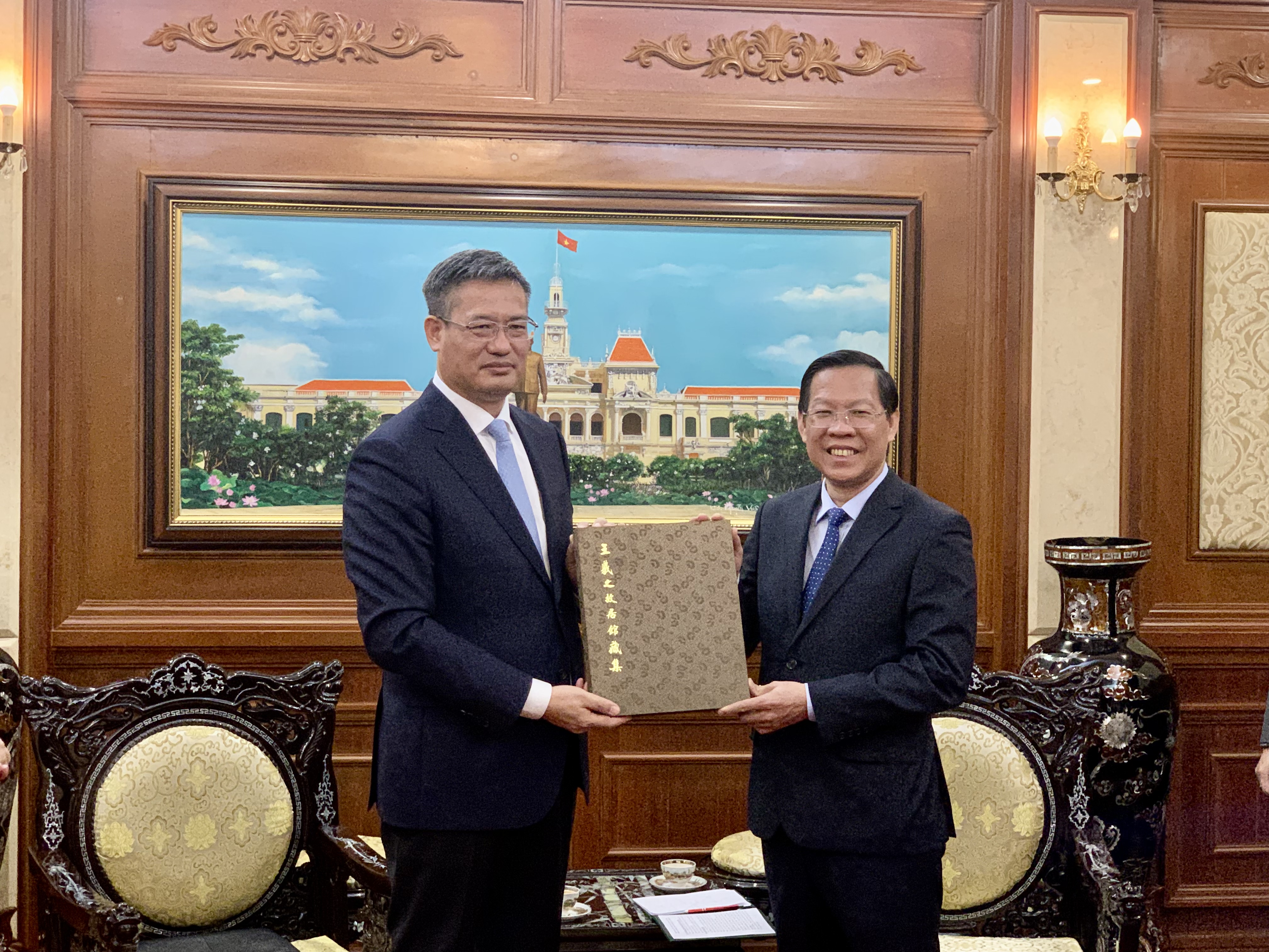 Chinese Consul General to Ho Chi Minh City Wei Huaxiang (L) presents a gift to Ho Chi Minh City chairman Phan Van Mai, July 7, 2022. Photo: Bao Anh / Tuoi Tre
