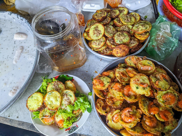 Trays of fried banh khot filled with prawns and minced pork at Co Gai’s stall in Phu Nhuan District, Ho Chi Minh City, Vietnam. Photo: Minh Duc / Tuoi Tre