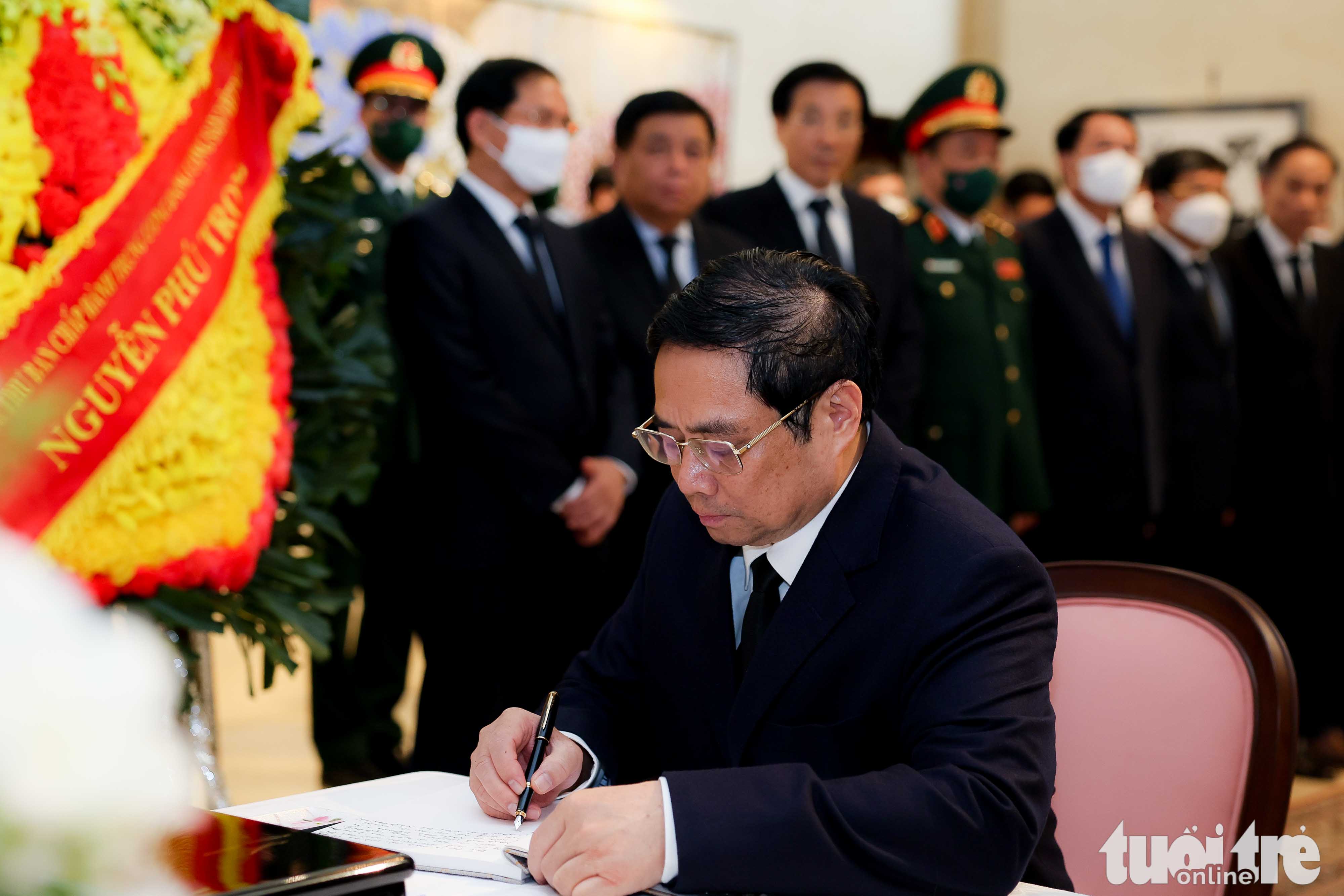 Vietnamese Prime Minister Pham Minh Chinh writes on the condolence book for former Japanese Prime Minister Shinzo Abe at the Embassy of Japan in Hanoi, July 11, 2022. Photo: Nguyen Khanh / Tuoi Tre