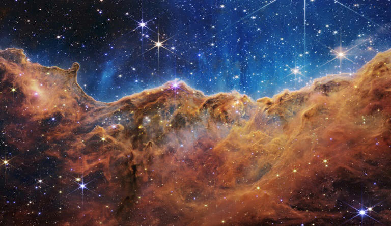 This image from the James Webb Space Telescope shows 'mountains' and 'valleys' speckled with glittering stars which is actually the edge of a nearby, young, star-forming region called NGC 3324 in the Carina Nebula.