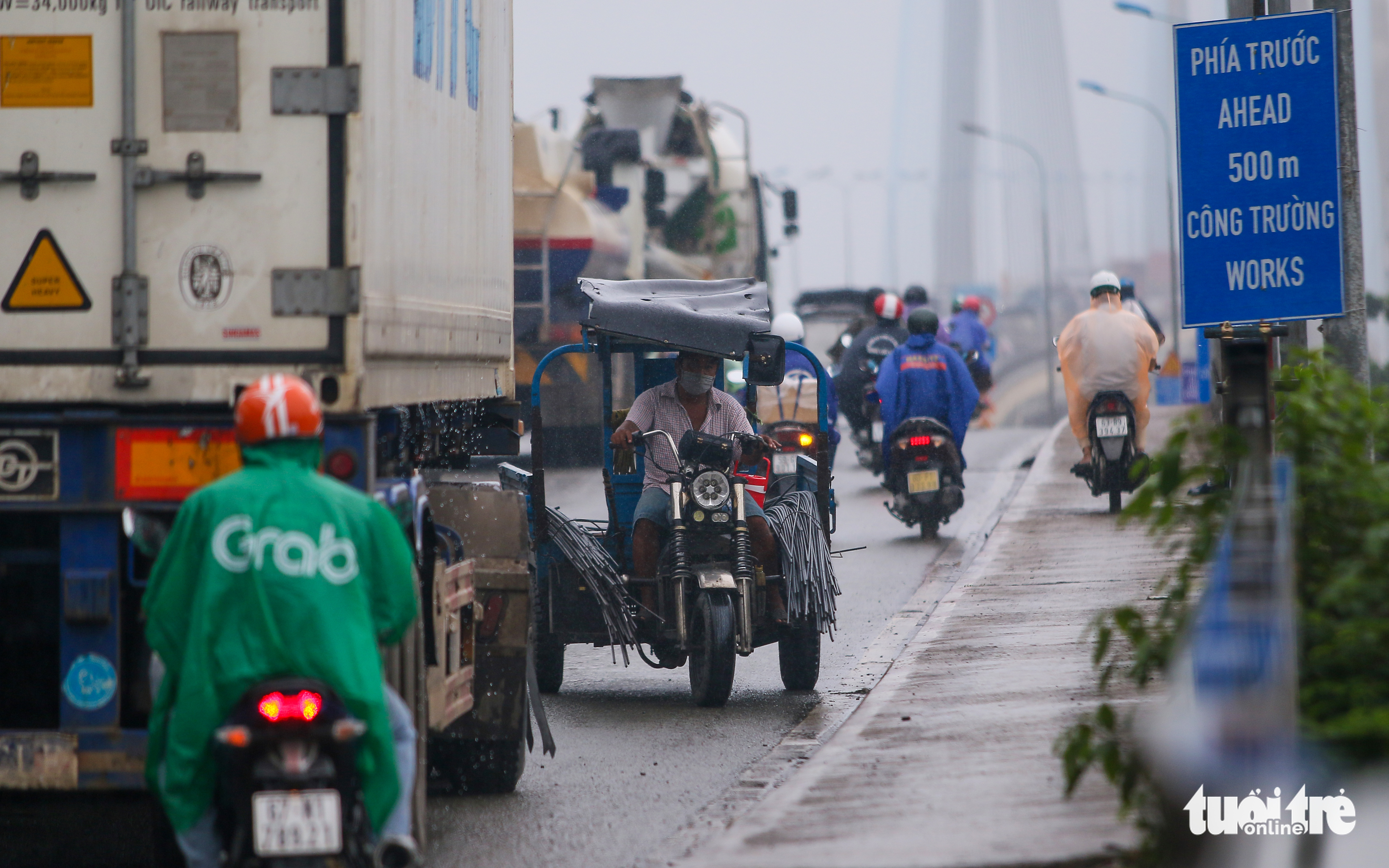 A motorcart travels in the wrong direction in an attempt to get away from the traffic jam on Phu My Bridge in Ho Chi Minh City, July 13, 2022. Photo: Chau Tuan / Tuoi Tre