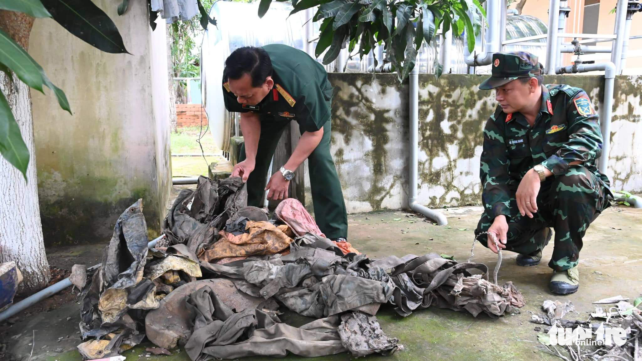 Military officers examine the objects belonging to the wartime aircraft in Tra Vinh Province, Vietnam. Photo: Huu Hiep / Tuoi Tre