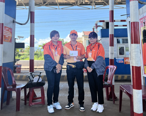 Tran Van Cong (C), Dang Le Huyen (R), and Tran Thi Thu Huyen recieve a reward for timely saving a mini truck driver suffering from a stroke attack at the Lien Dam toll station in Di Linh District, Lam Dong Province, Vietnam, June 12, 2022. Photo: Lien Dam toll station