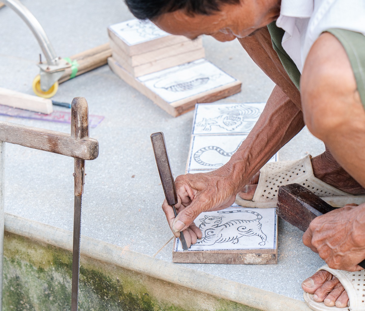 Artisan Phuoc creates a woodblock, using simple tools. He said the job requires artisans to be skillful to create woodblocks which can be handed down to future generations. Photo: Nguyen Trung Au / Tuoi Tre News