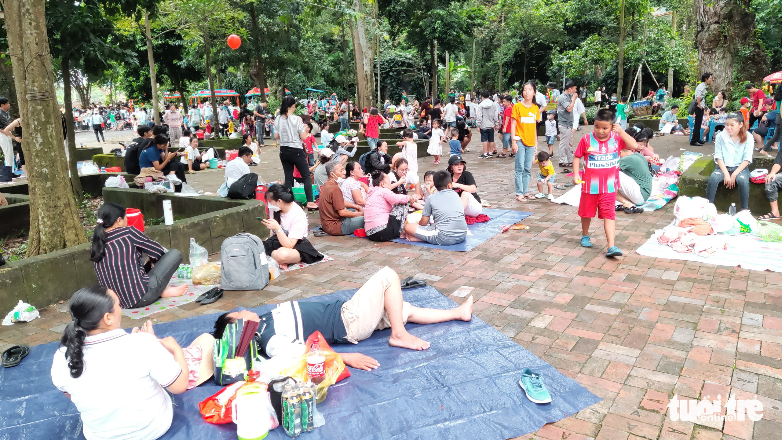 People rest on mats at the Saigon Zoo and Botanical Gardens in District 1, Ho Chi Minh City, July 17, 2022. Photo: N. Tri / Tuoi Tre